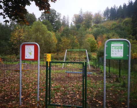 Na zdjęciu widoczne jest ogrodzenie, wejście do placu zabaw oraz regulamin korzystania.