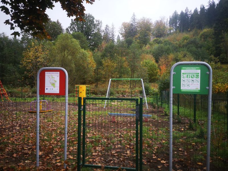 Na zdjęciu widoczne jest ogrodzenie, wejście do placu zabaw oraz regulamin korzystania.